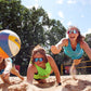 Frauen springen nach Beachvolleyball im Sand