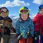 3 Skikinder auf einer Schaukel
